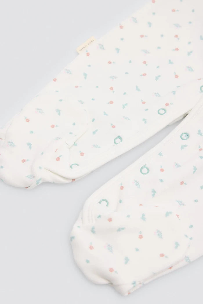 Pelele bebé estampado blanco Ysabel Mora con flores y pies antideslizantes