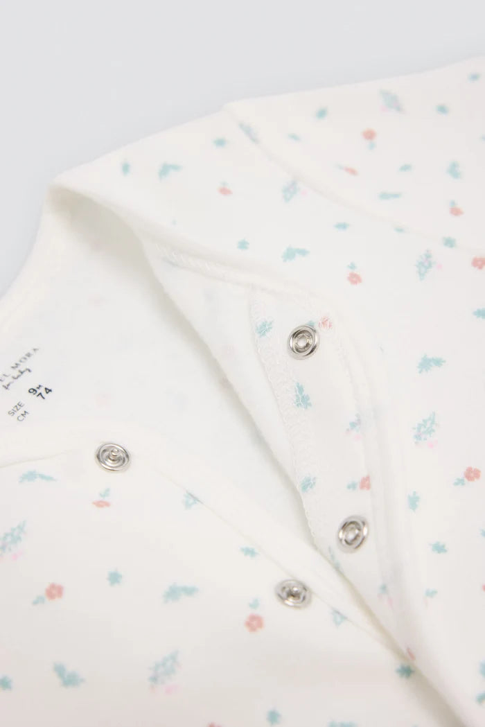 Pelele bebé estampado blanco Ysabel Mora con flores y pies antideslizantes